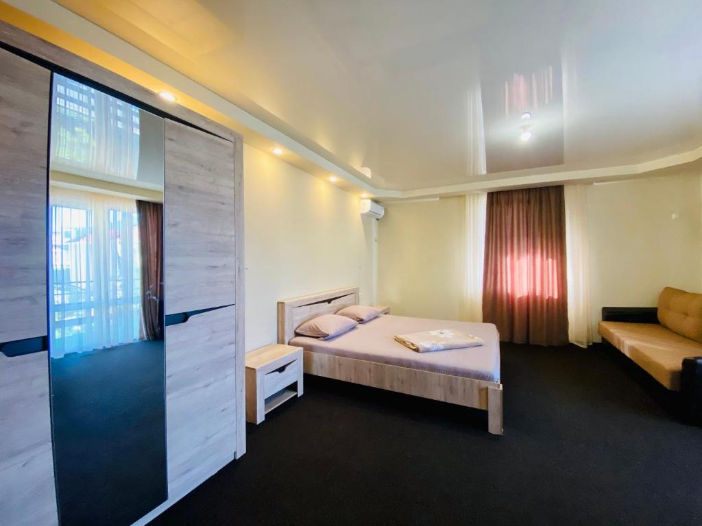 ラザレフスコエにあるGuesthouse Ridadのベッドルーム1室(ベッド1台、ソファ付)