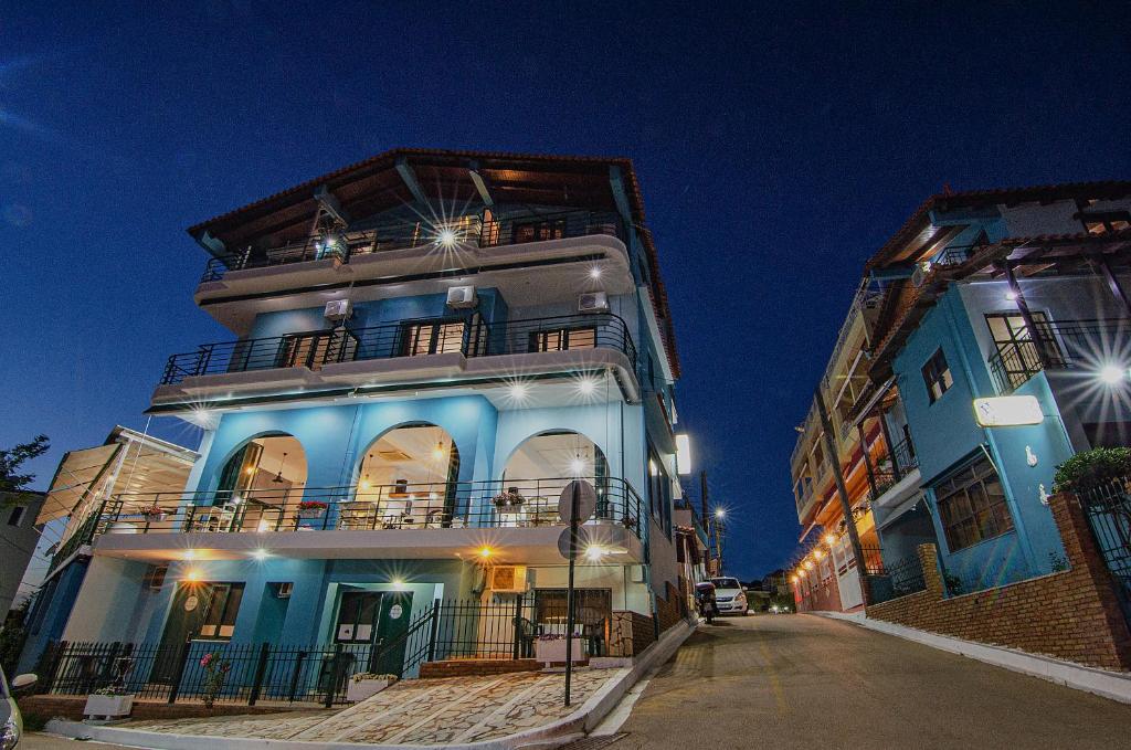 a blue building with a balcony on a street at Soulis Hotel in Arkoudi