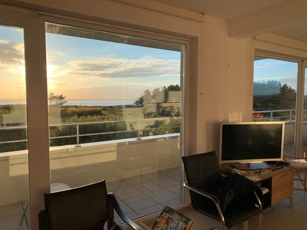a living room with a large window and a television at Vue Mer, Golfe et Dunes- Résidence Dunes du Golfe in Wimereux