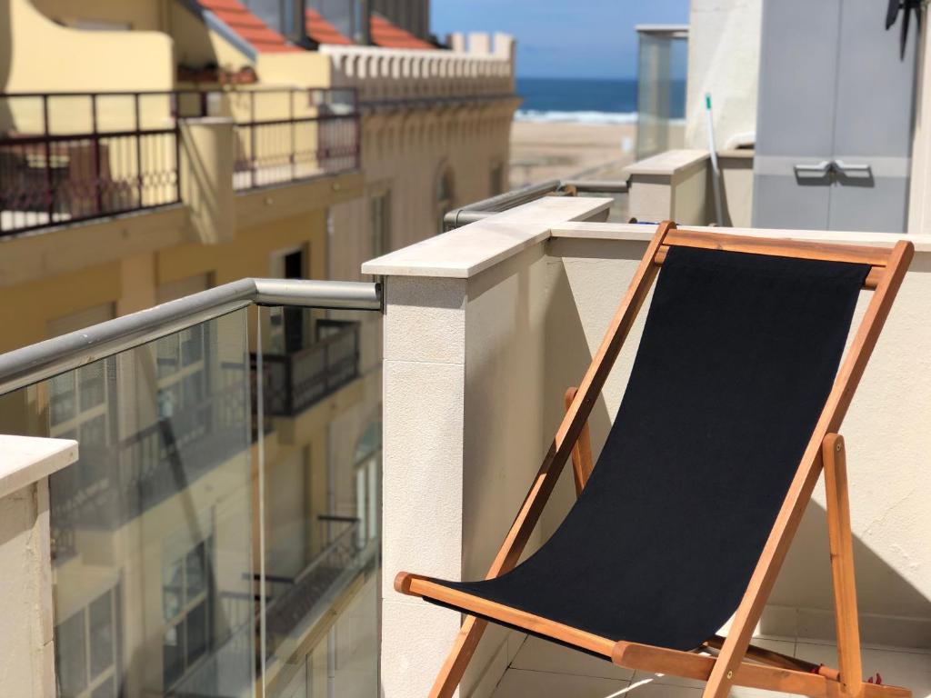 a black chalkboard sitting on top of a balcony at king's tower by Férias em Figueira in Figueira da Foz