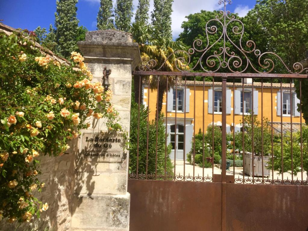 una puerta delante de una casa amarilla en Chambres d'hôtes La Borderie du Gô près de La Rochelle - Nieul, en Nieul-sur-Mer