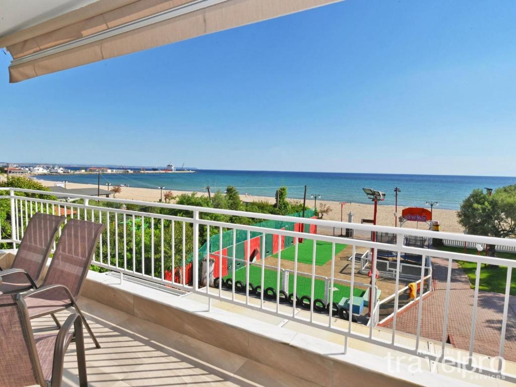 ネア・ムダニアにあるSabbia Apartments Seafront by RentalsPro - Nea Moudania Halkidikiのビーチの景色を望むバルコニー(椅子付)