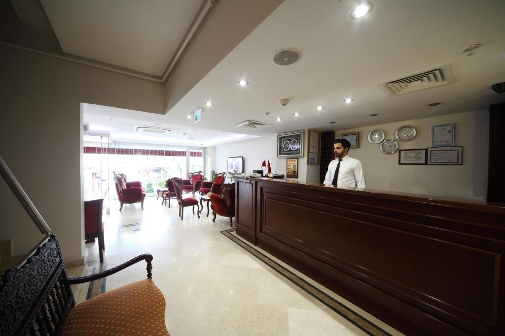 a man standing at the counter of a waiting room at Istanbul Newcity Hotel in Istanbul