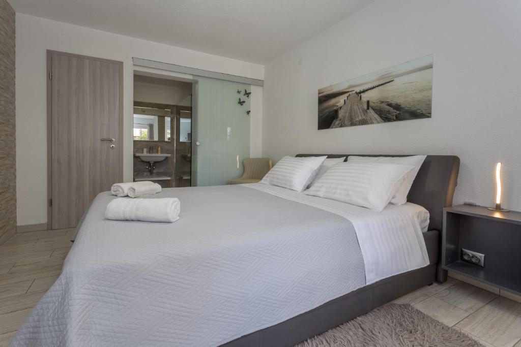 a bedroom with a large bed with two towels on it at Hvar luxury rooms in Hvar