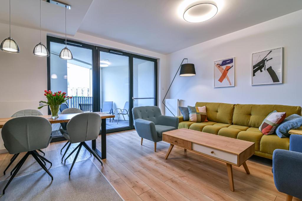 ein Wohnzimmer mit einem gelben Sofa und einem Tisch in der Unterkunft LTC-Apartments Portova in Gdynia