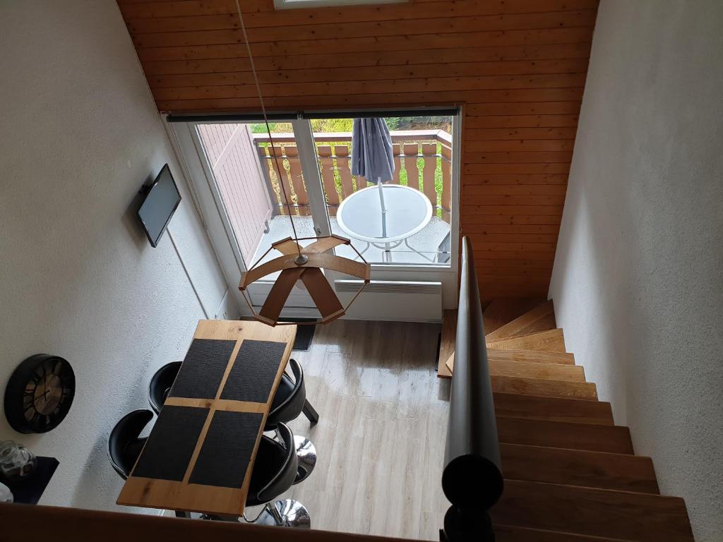 シャテルにあるAppartement Châtelの階段、テーブル、窓が備わる客室です。