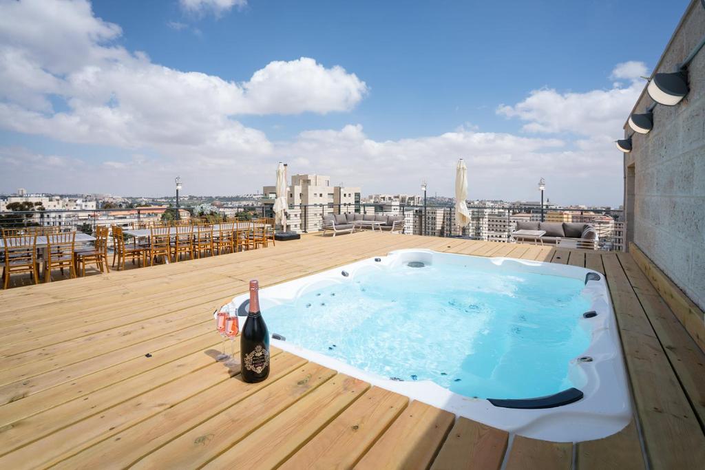 Una botella de vino sentada en una bañera de hidromasaje en el techo en EVEN ISRAEL PENTHOUSE- JACUZZI- 5 royal Masters, en Jerusalén