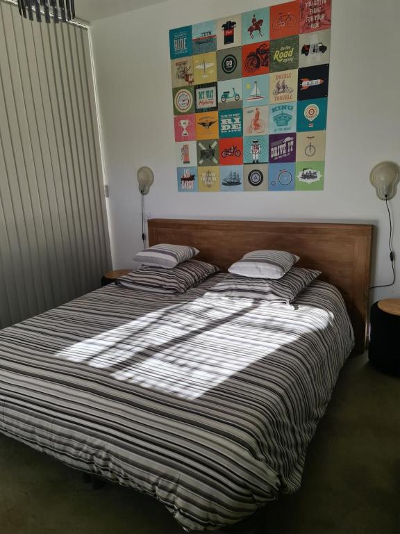 Évenosにあるle gîte des cadièresのベッドルームにストライプ掛け布団付きのベッド1台