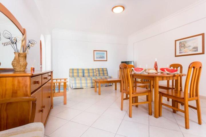 eine Küche und ein Esszimmer mit einem Tisch und Stühlen in der Unterkunft calm beach apartement in Portimão