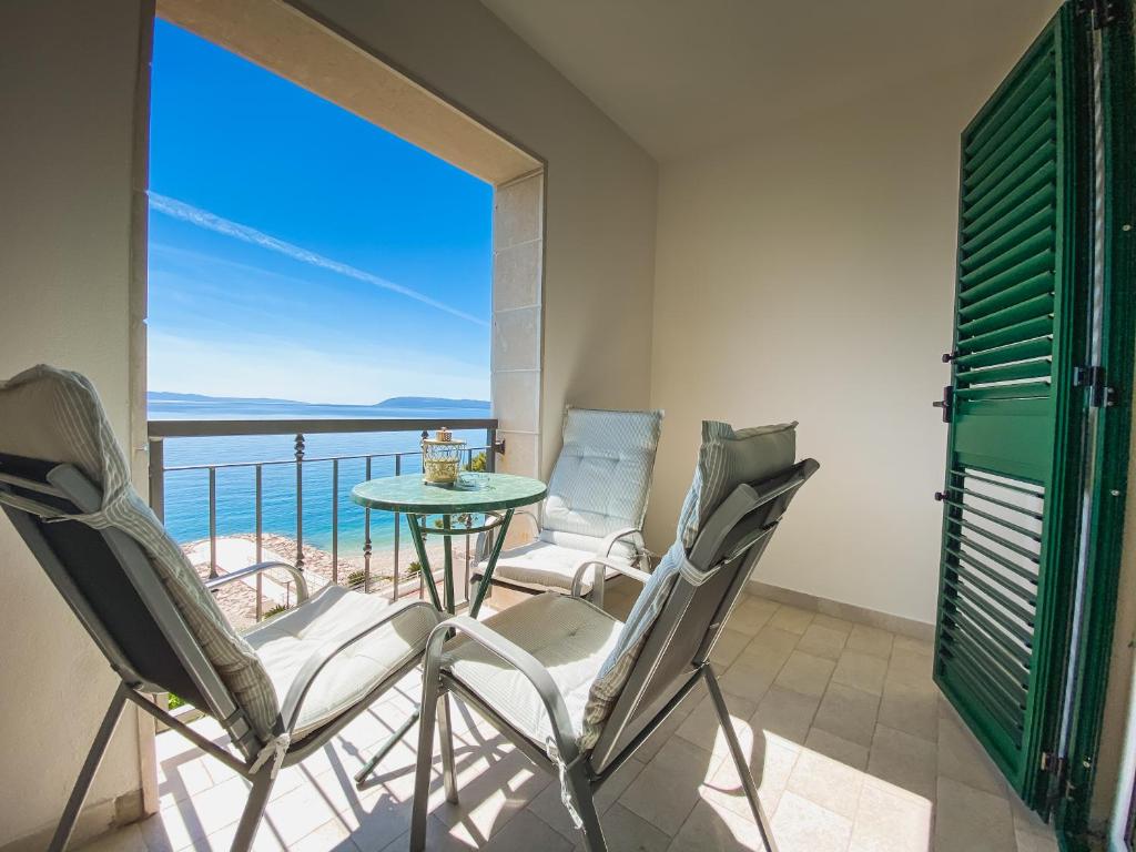 a balcony with a table and chairs and a view of the ocean at Apartments Luketina in Tučepi