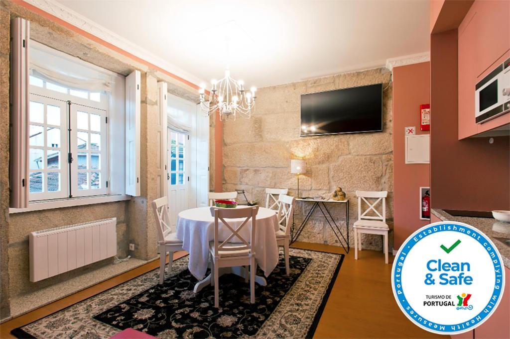 a dining room with a table and a tv on a wall at Oporto Center Clean & Cozy Apt 3 in Porto