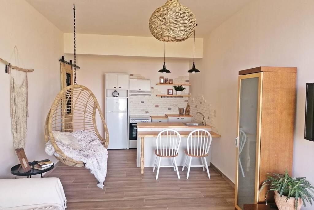 una cucina con tavolo e sedie in una stanza di ALKYONI - Stavi's Guesthouse a Míloi