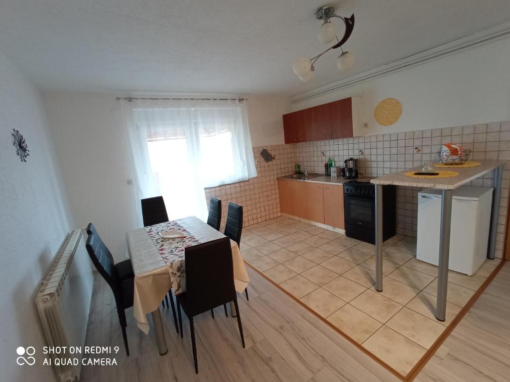 a kitchen and dining room with a table and a table and chairs at Apartment LIKA in Gospić