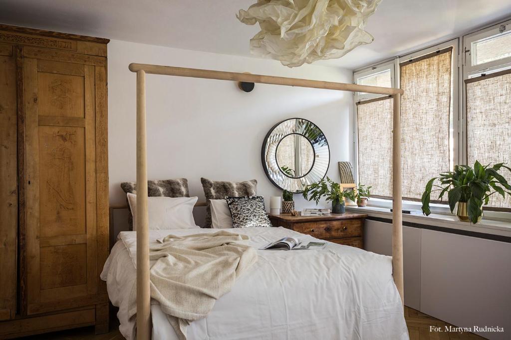 ein Schlafzimmer mit einem Himmelbett und einem Spiegel in der Unterkunft Opera Art Apartment Vintage Slow in Warschau