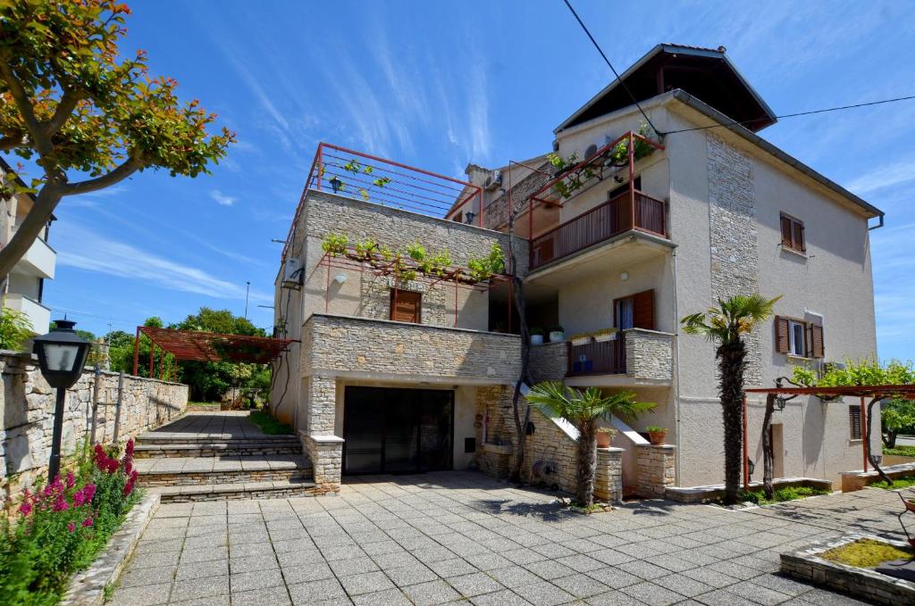 a large white building with a courtyard and trees at GALANT apartments in Rovinj