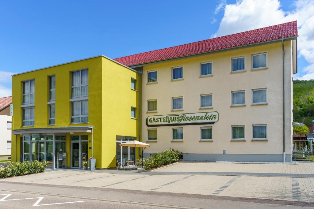 un hotel con un edificio blanco y amarillo en Hotel Rosenstein, en Heubach