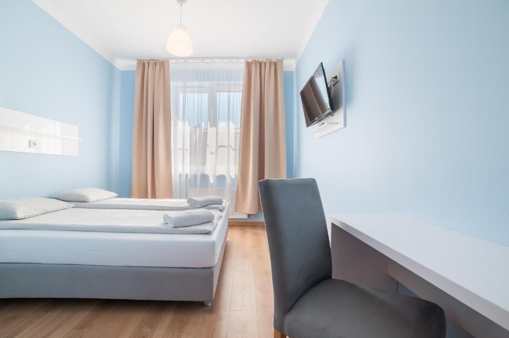 1 Schlafzimmer mit 2 Betten und einem Stuhl in der Unterkunft Freedom Hostel in Krakau