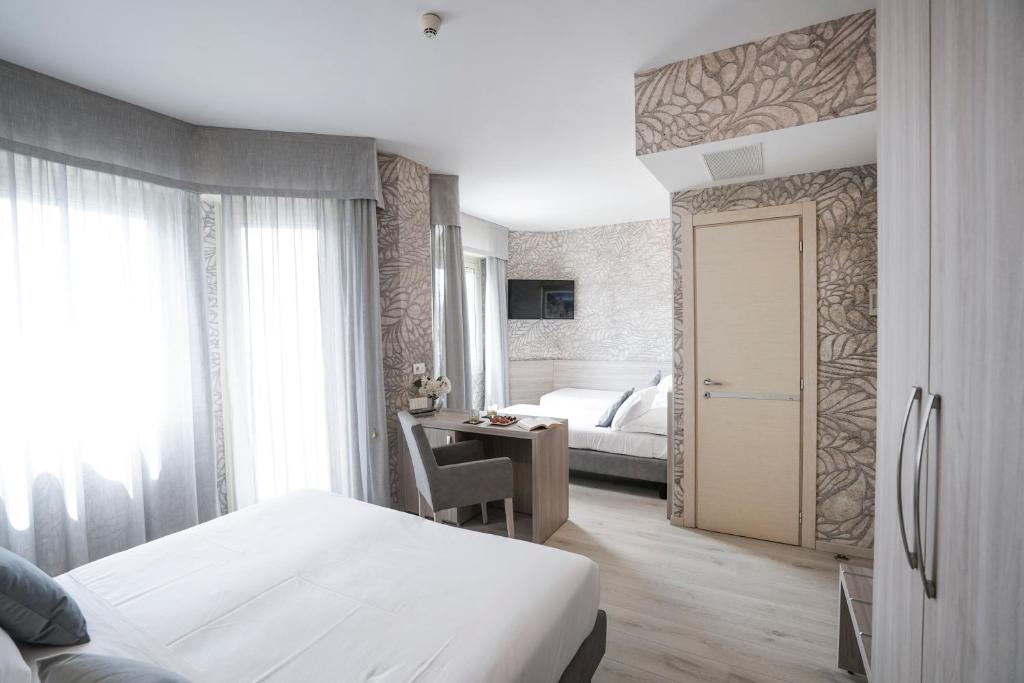 a hotel room with a bed and a desk and a door at Sole Mare in Ventimiglia