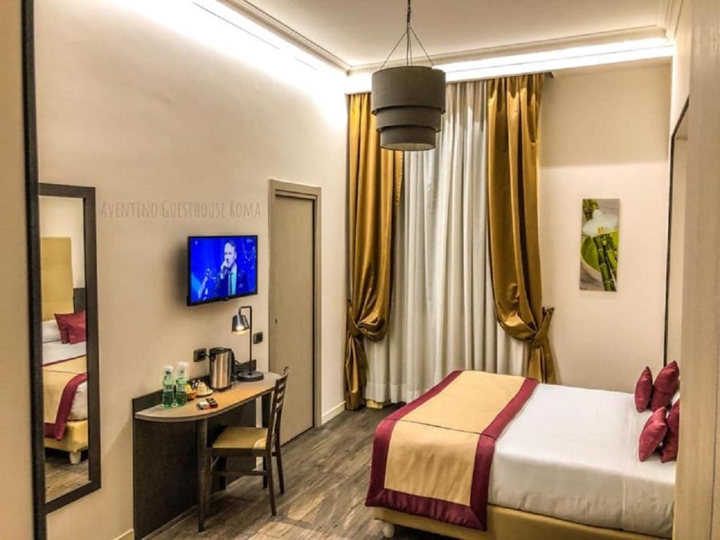 羅馬的住宿－阿維提諾賓館，配有床和书桌的酒店客房
