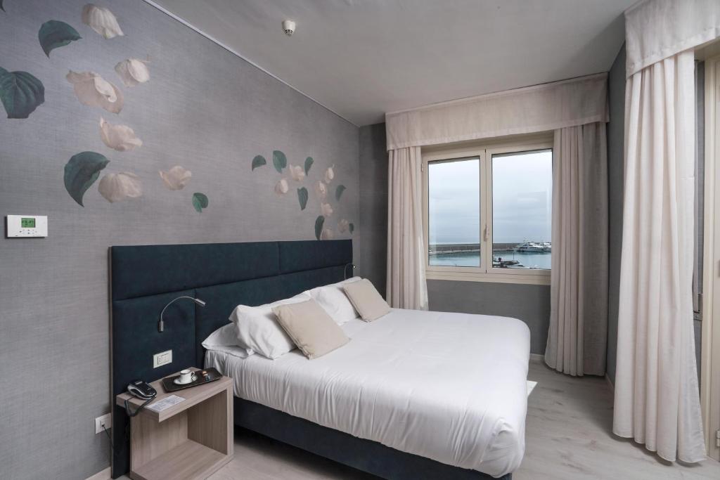 a bedroom with a white bed and a window at Sole Mare in Ventimiglia