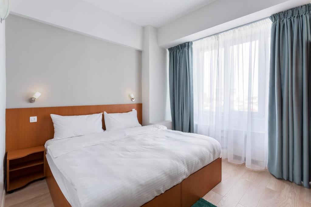 a bedroom with a bed and a large window at Elizeu Hotel in Bucharest