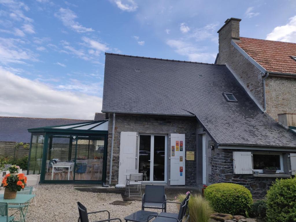 Ce cottage en pierre comprend une table et des chaises. dans l'établissement Les fleurs du Mont, à Céaux