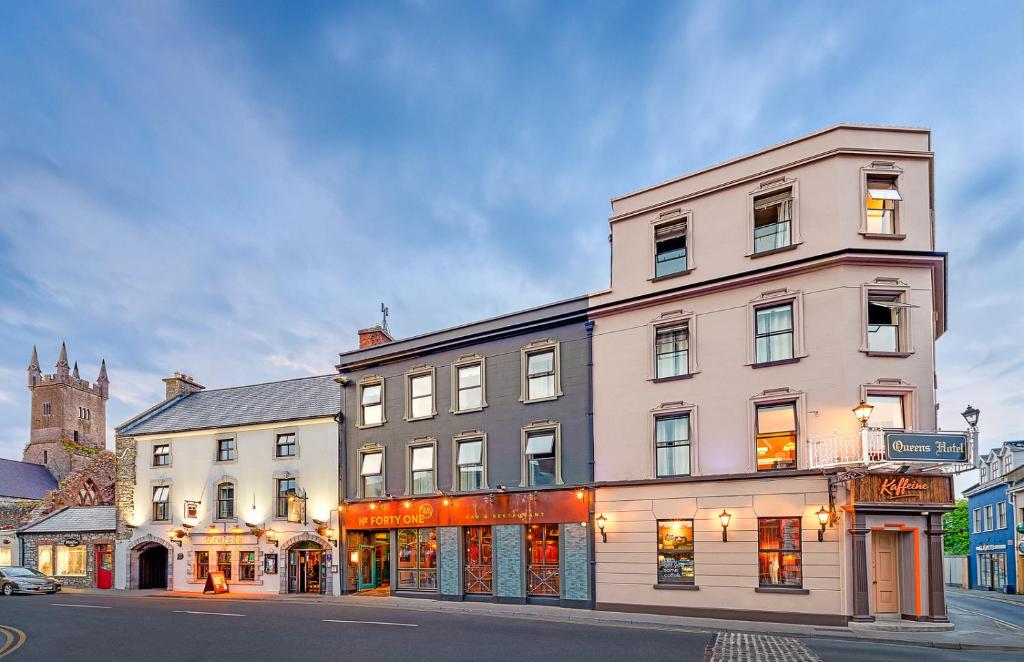 - un grand bâtiment blanc dans une rue de la ville dans l'établissement Queens Hotel, à Ennis