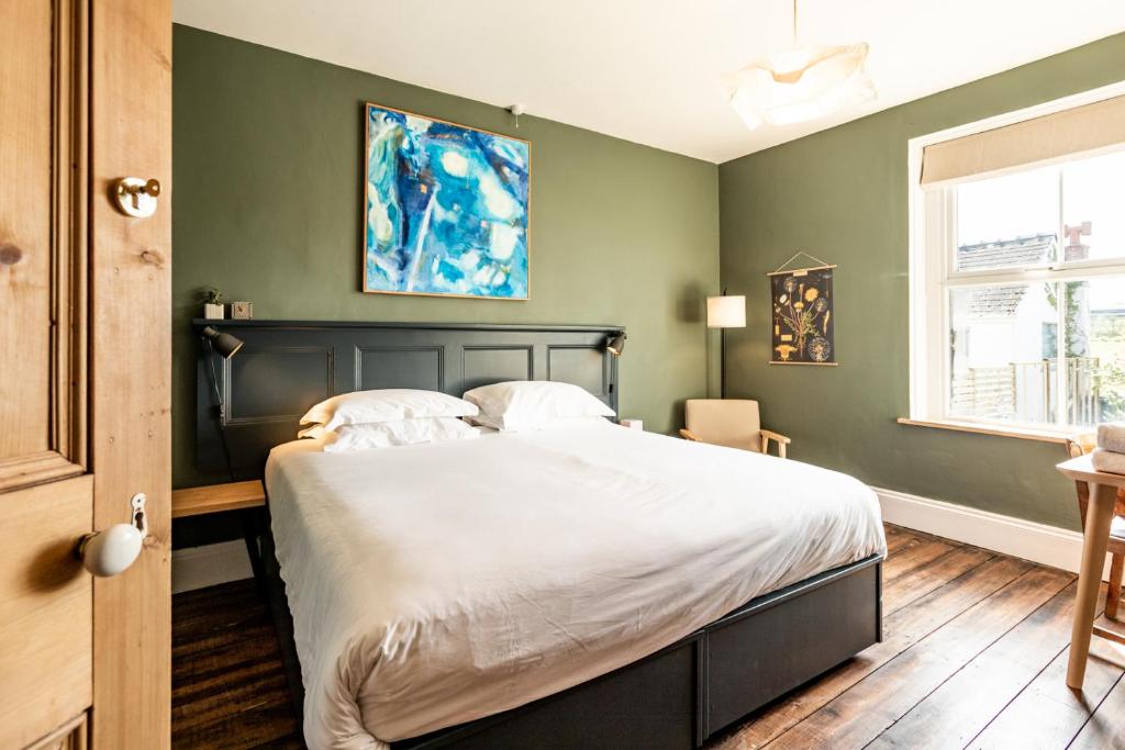 a bedroom with a large bed with green walls at The Old Vicarage in Cardigan