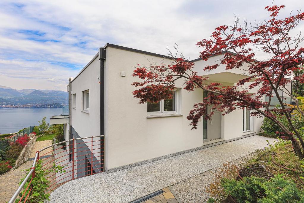 biały dom z widokiem na wodę w obiekcie Skylake Penthouse by Impero House w mieście Stresa