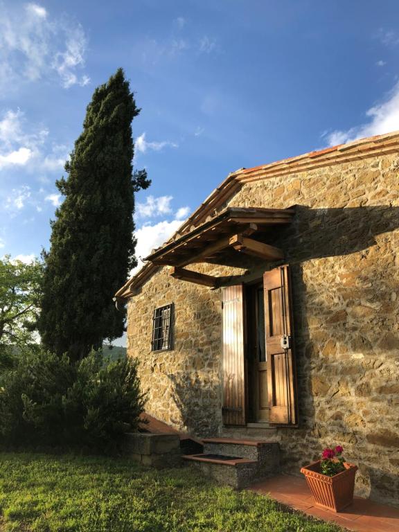 une ancienne maison en pierre avec une porte en bois dans l'établissement Podere Pruneto, à Radda in Chianti