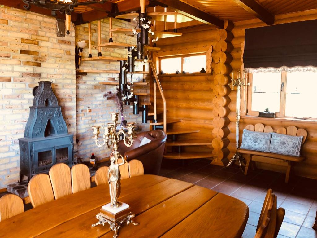 a wooden dining room with a table and a fireplace at Villa Lotus in Zhemoytele