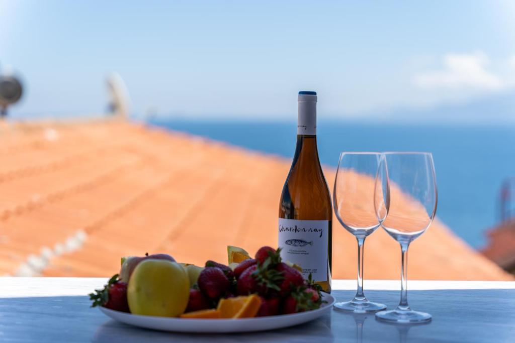 una bottiglia di vino e due bicchieri di vino su un tavolo di Simple Pleasures Home a Kavala
