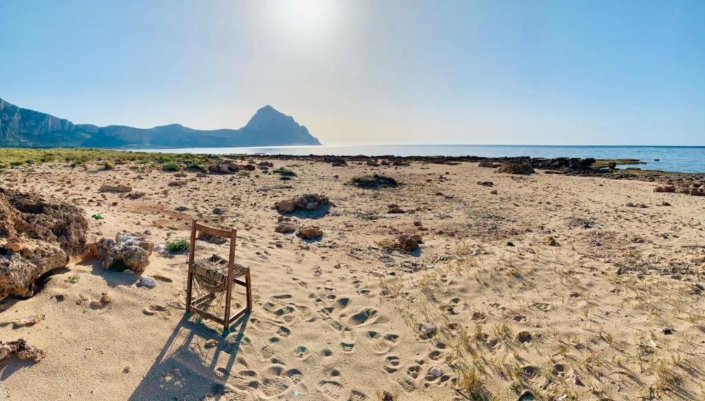 una silla sentada en una playa junto al océano en La Terrazza Di San Vito, en San Vito lo Capo
