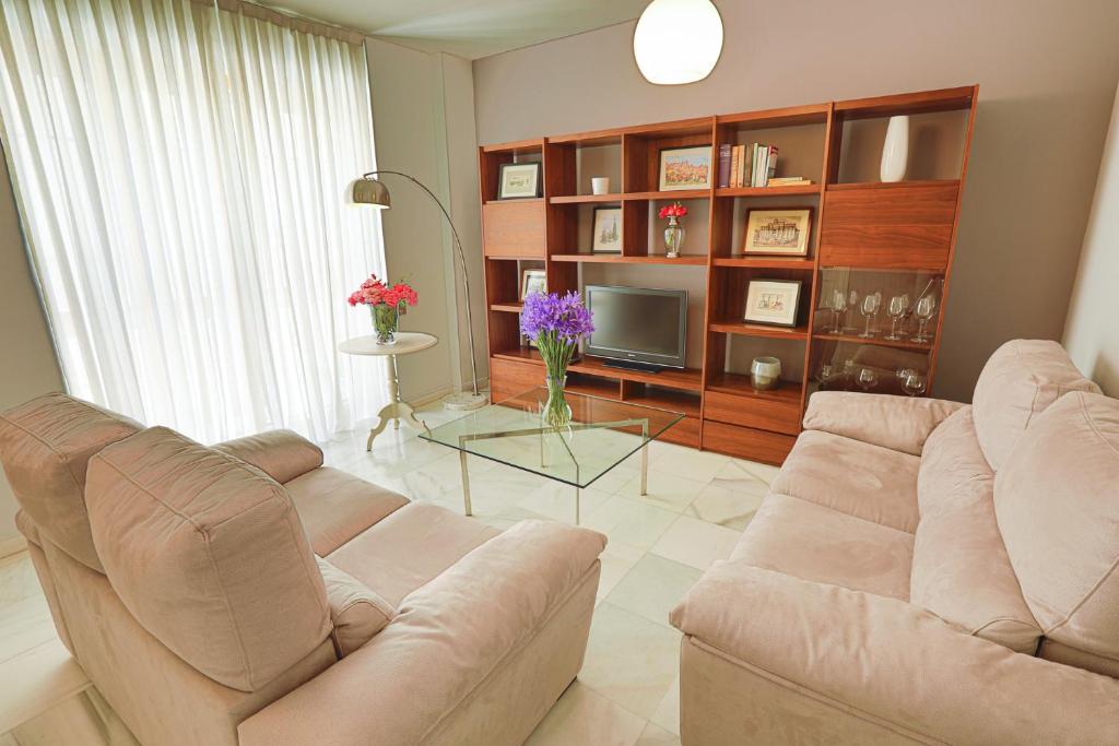 a living room with a couch and a television at Piso Triana, Sevilla in Seville