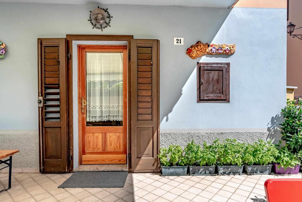 a door of a house with some plants next to it at Casa Mincoti Piazza Terragnolo OSPITAR in Piazza