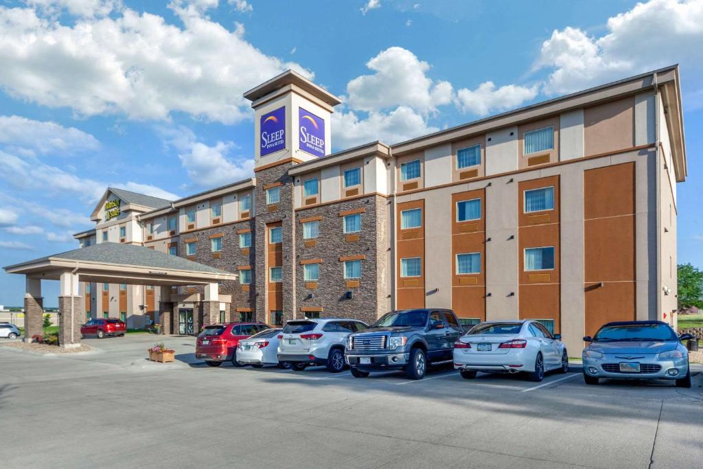 a hotel with cars parked in a parking lot at Sleep Inn & Suites Lincoln University Area in Lincoln