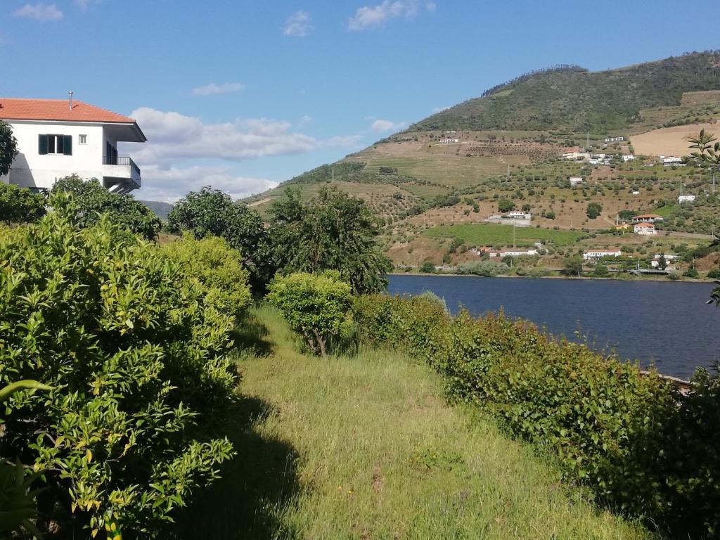 ein Haus auf einem Hügel neben einem See in der Unterkunft Casa do Rio in Covelinhas