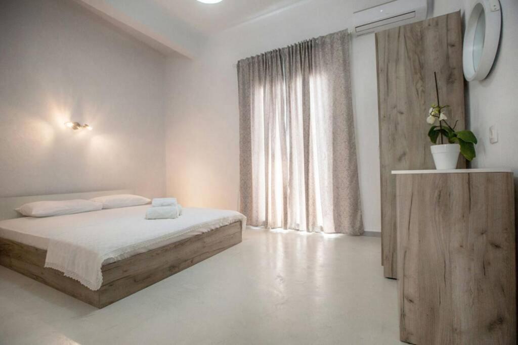 biała sypialnia z łóżkiem i oknem w obiekcie Athina's home 2 w mieście Ajos Nikolaos