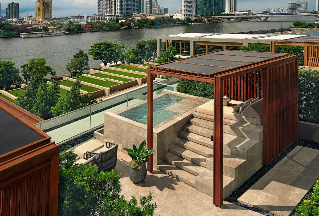 A rooftop pool terrace overlooking the Chao Phraya River and Bangkok skyline.
