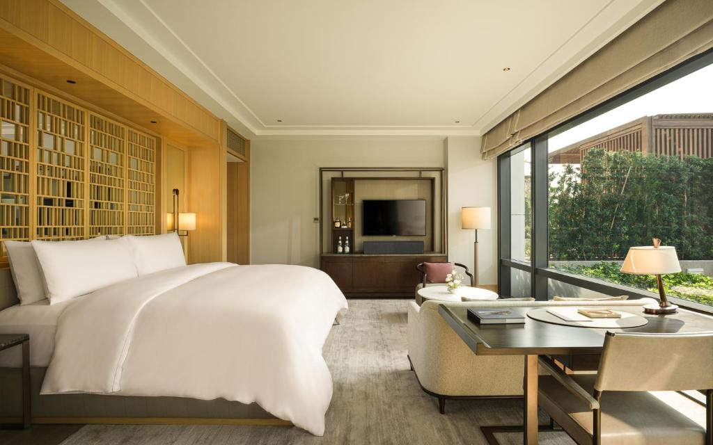 A refined bedroom with a television wall, writing desk and large glazed outlook.