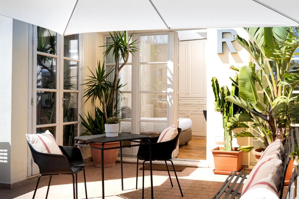 a table and chairs in a room with plants at Leopoldo Rooms in Cagliari