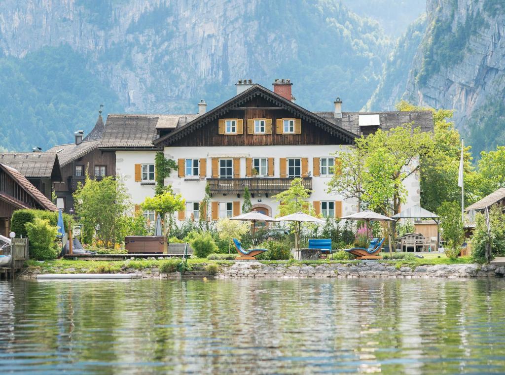 ein großes Gebäude neben einem Wasserkörper in der Unterkunft Glück am See - Apartment mit Seezugang in Hallstatt