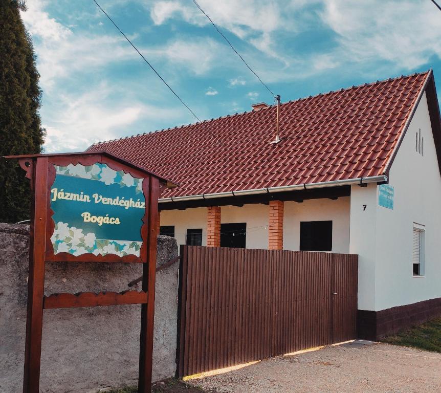 una señal frente a un edificio con una valla en Jázmin vendégház Bogács, en Bogács