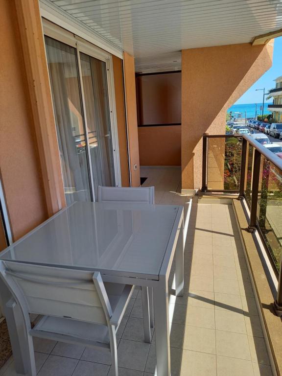 una mesa en un balcón con vistas al océano en K&S 68 Appt Standing vue mer - Garage Inclus, en Roquebrune-Cap-Martin