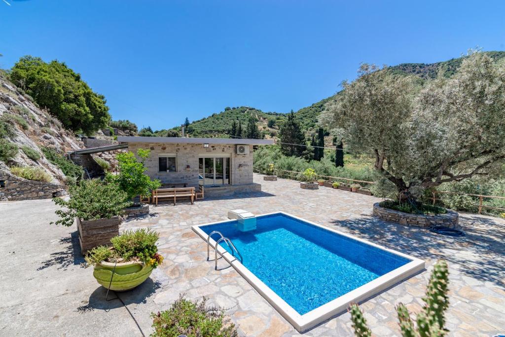 a backyard with a swimming pool and a house at Cretan Nature Villa Alexandra in Zarós