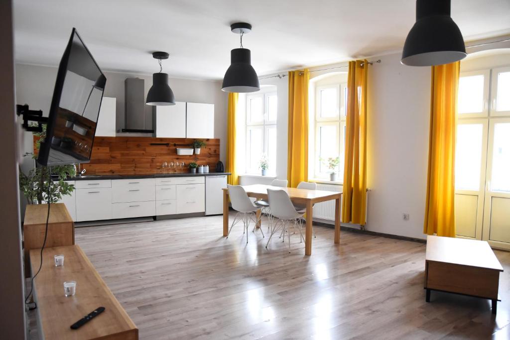 a kitchen and dining room with a table and chairs at Perfect Stay - "Apartamenty Horzyca" in Toruń