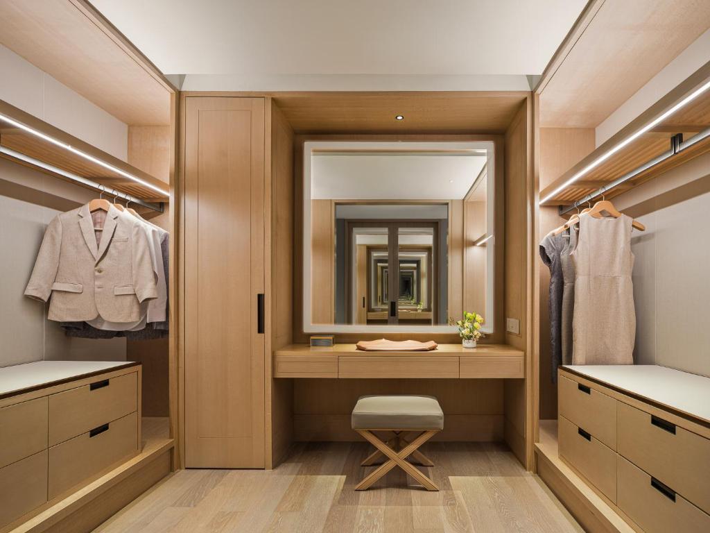 A built-in dressing room with a central vanity and extensive open wardrobe storage.