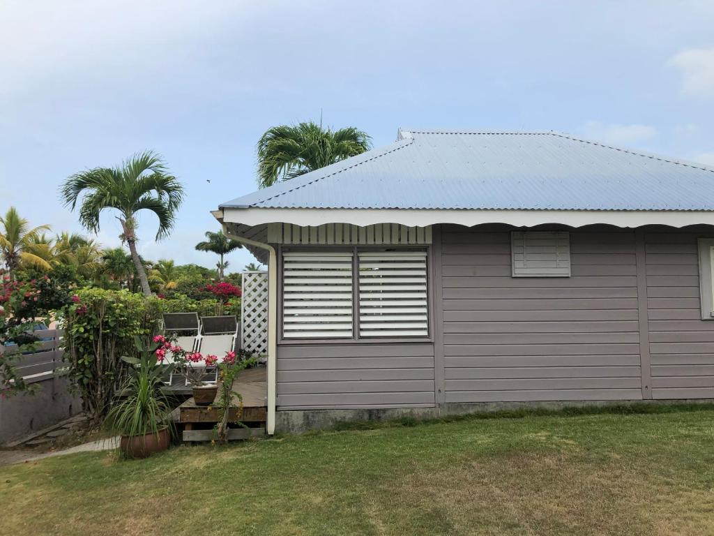 a garage next to a house with palm trees at TI-MANGO VUE MER in Sainte-Anne
