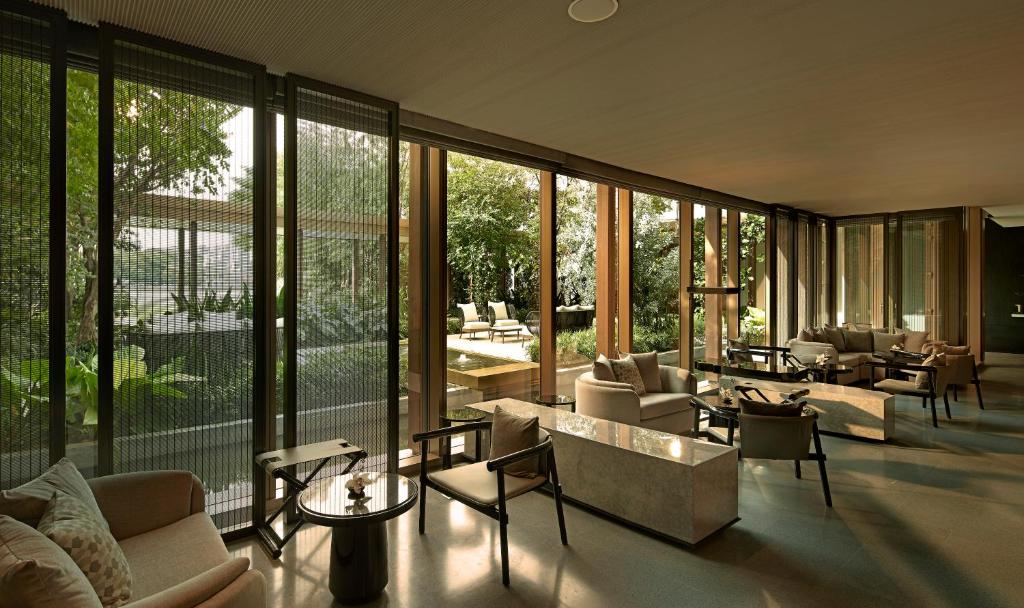 A sunlit lounge with floor-to-ceiling windows and garden views.
