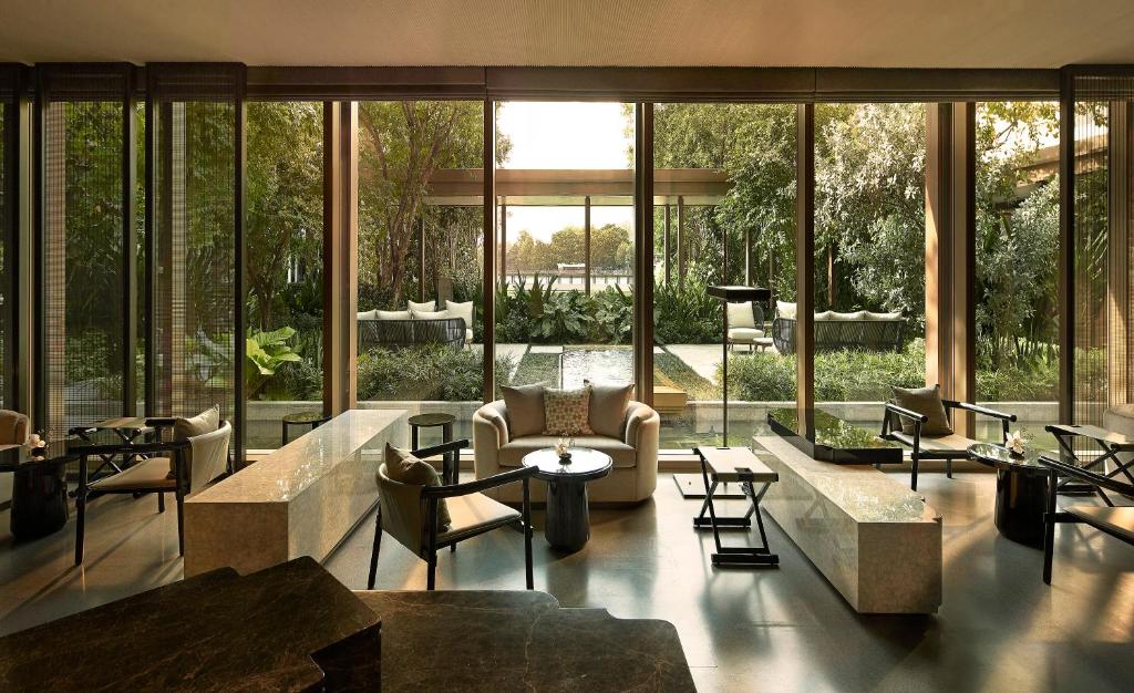 A bright glass-fronted lounge overlooking a planted garden.